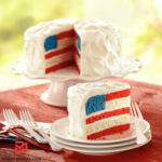 A vibrant and patriotic American Flag Cake stands proudly, showcasing its layers of red, white, and blue. The cake is adorned with meticulous details, from the precisely decorated stars on the blue rectangle to the luscious berries accentuating the red and white stripes. This delectable masterpiece captures the essence of celebration, inviting you to indulge in a slice of delicious history and national pride.