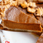 A golden-brown, perfectly baked pumpkin pie with a velvety smooth filling, embodying the essence of fall flavors. 🍂🥧 #FallDesserts #HomemadePie