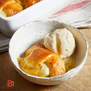 Image: A close-up view of Grandma's Apple Dumplings, featuring golden-brown pastry encasing tender baked apples, generously coated with a cinnamon sugar glaze. The picture captures the delectable essence and nostalgic charm of this beloved homemade dessert, inviting you to experience the comforting flavors and tradition in every bite.