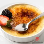 Ingredients for a classic dessert, including heavy cream, vanilla bean, egg yolks, and sugar, arranged on a kitchen counter