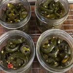 Close-up of homemade candied jalapeños on a wooden cutting board