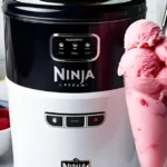 A bowl of creamy Ninja Creami Raspberry Sorbet topped with fresh raspberries and mint leaves.