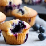 Stack of mini blueberry muffins served on a plate.