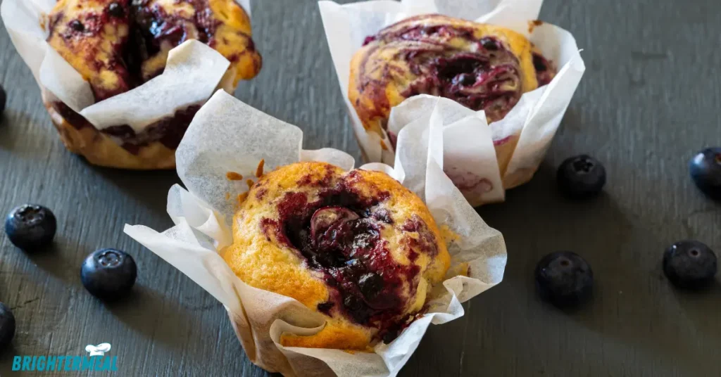 Close-up of mini blueberry muffins with a golden-brown top.
