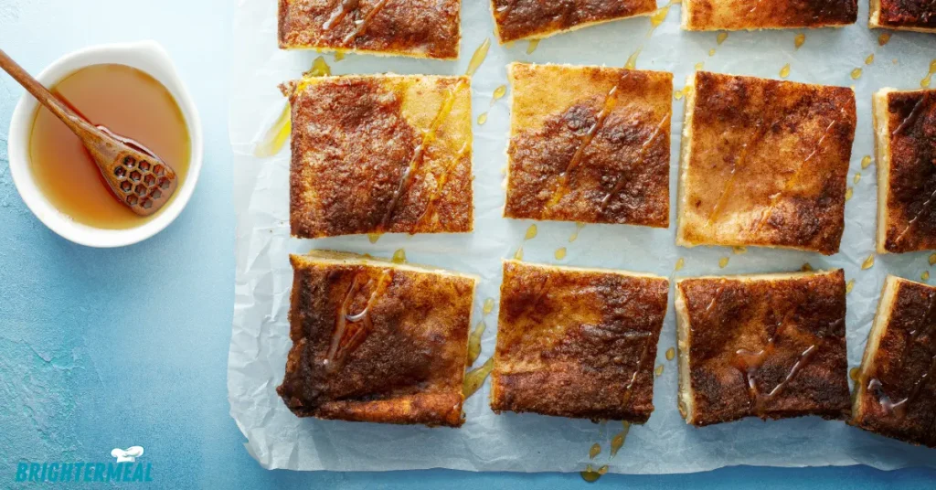 Churro cheesecake bars with a golden brown cinnamon sugar topping.