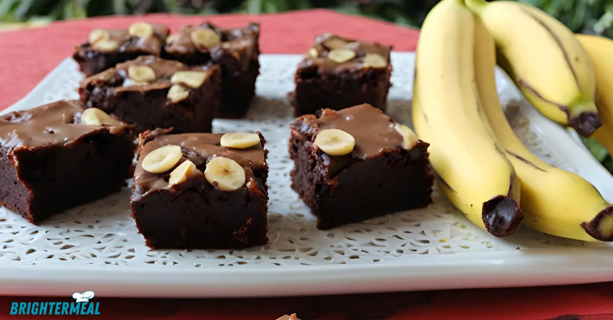 Stack of banana brownies on a plate, with nuts and chocolate chips.