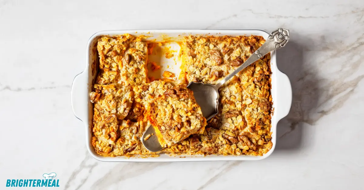 Close-up of baked pumpkin dump cake with chopped pecans.