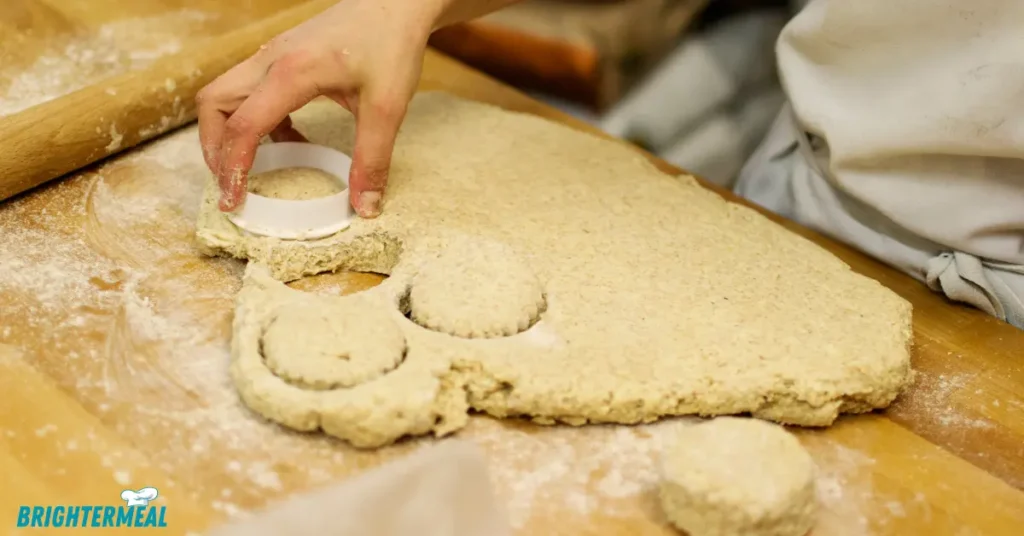 Scone dough being shaped on a floured surface.
