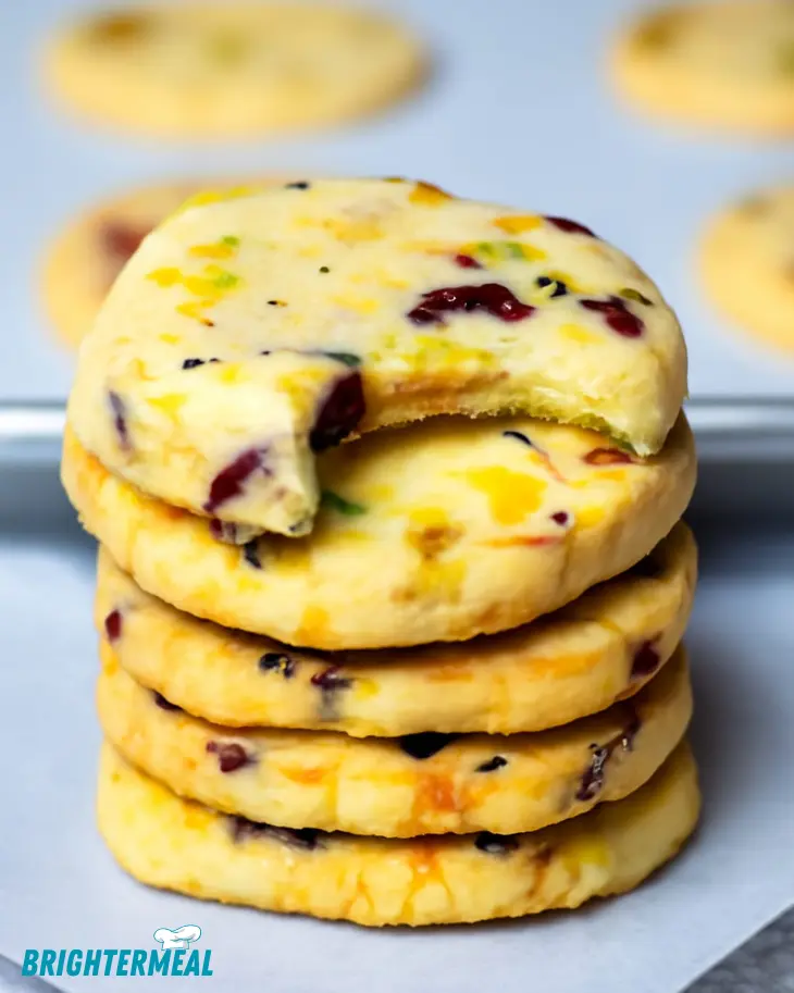 Cranberry pistachio shortbread cookies stacked on a plate.