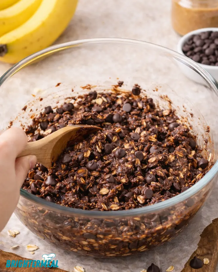 Mixing oats cocoa and banana for no-bake chocolate banana squares